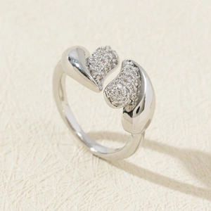 Detail of adjustable silver ring with twin hearts featuring half-pave cubic zirconia