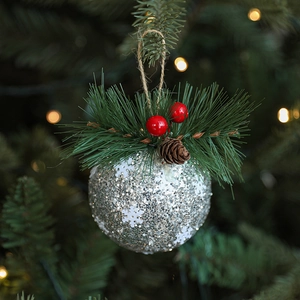 Sparkling silver Christmas ball ornament with snowflake pattern, pine needles and pinecone