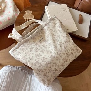 Detailansicht einer Baumwolltasche mit Blumenmuster und Simple Wish Label auf Holztisch