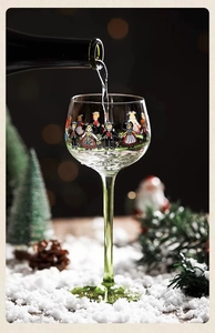 Macro detail of Alsace wine glass with traditional figures and green stem for Christmas