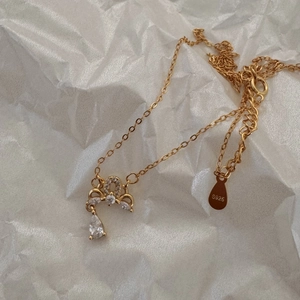 Close-up of S925 sterling silver crown necklace with shimmering cubic zirconia teardrop