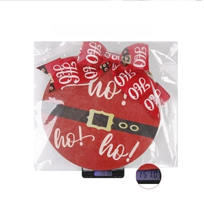Detail view of round wooden Christmas door sign with bow being weighed on a scale