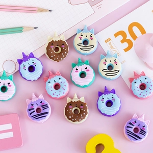 Cute unicorn donut erasers in assorted colors scattered on a creative school desk setup