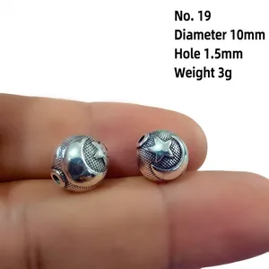 Macro view of retro silver lantern bead with star and moon relief and textured finish