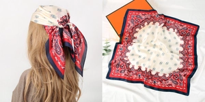 Detail of red and navy paisley square scarf showing material texture and pattern