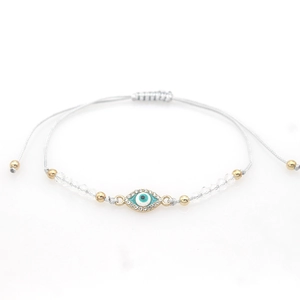 Braided evil eye bracelet with crystal beads and gold accents on gray adjustable cord