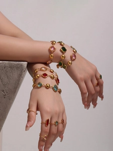 Detailed view of bohemian gold bracelets and rings set with vibrant colorful gemstones