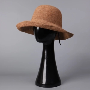 Close-up of dark brown raffia straw sun hat showing dense handmade woven texture