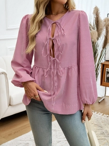 Detail of pink striped long sleeve top with V-neck tie-up design and pleated hemline