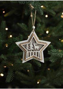 Close-up of a white wooden star ornament with reindeer silhouette on a Christmas tree