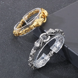 Detailed shot of gold and silver dual snake head bracelets in Byzantine style chain