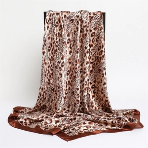 Macro shot showing the draped texture and leopard print of a satin silk square scarf