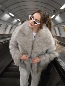 Chic light gray faux fur coat with wide lapels styled in a modern metro station setting