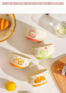 Close-up of ceramic bowls with hand-painted cartoon donuts and croissant patterns