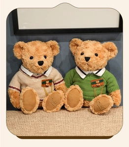 Detail of two teddy bears in knit sweaters with intricate Teddy embroidery on paw