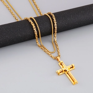 Detail of gold double-layer cross pendant with box chain and rope chain texture