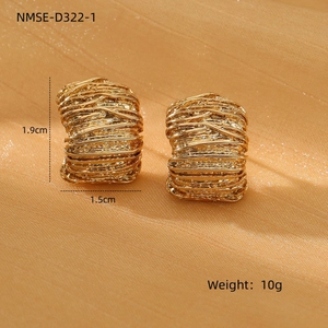 Macro detail of gold textured earrings with size 1.9x1.5cm measurements on silk background