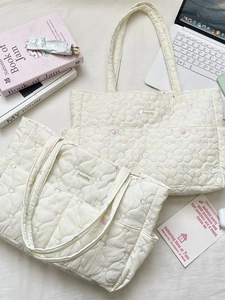 Cream quilted flower tote bag with heart patterns shown in a stylish lifestyle setting