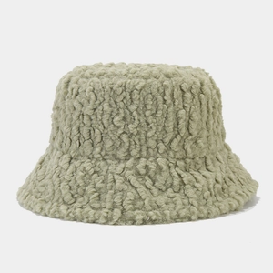 Detail shot of soft green teddy fleece texture on a thick plush winter bucket hat