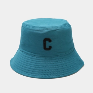 Détail du chapeau bob en coton bleu sarcelle avec la lettre C noire brodée sur le devant