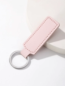 Detail of pink lychee texture leather keychain on a white stone minimalist pedestal
