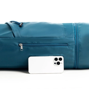 Detail view of the blue yoga mat bag showing functional zipper pockets and durable nylon fabric