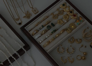 Collection of vintage gold-plated honeycomb rings and pearl jewelry in a display tray
