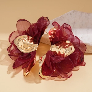 Vue détaillée des boucles d'oreilles fleurs en mousseline bordeaux et métal doré martelé