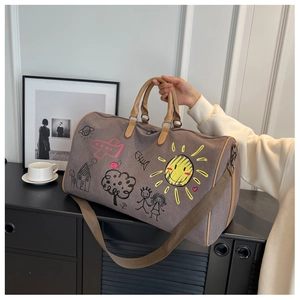 Detail of travel bag with colorful hand-drawn graffiti patterns and leather handles