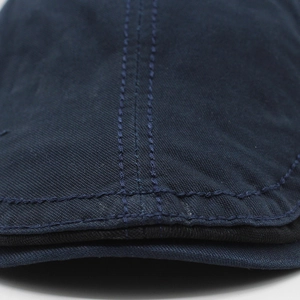 Detail of navy blue cotton beret showing double-stitched brim and premium canvas texture