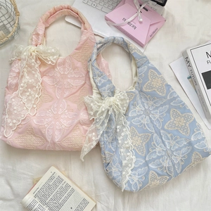 Détails de broderies florales et nœuds en dentelle sur sacs fourre-tout rose et bleu