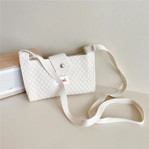 Close-up of cream knitted phone bag featuring diamond texture and silver magnetic snap