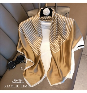 Detail of elegant champagne gold and white chevron silk scarf draped on a floral hanger