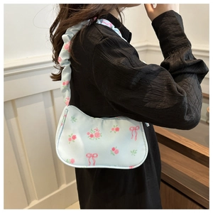 Light blue underarm bag with pink roses and bow prints, featuring ruffled shoulder straps