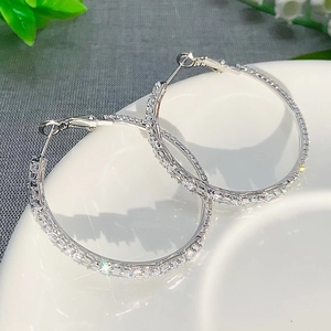 Macro close-up of luxurious silver hoop earrings with shimmering cubic zirconia stones
