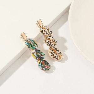 Detailed close-up of shell hair clips with leopard and colorful patterns on metal base