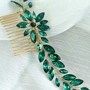 Close-up of bridal hair comb with emerald green marquise crystals and gold wire mesh