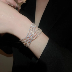 Détail d'un bracelet croisé double couche serti de diamants brillants au poignet