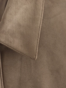 Close-up of high-quality faux suede fabric texture and neat stitching on a brown jacket