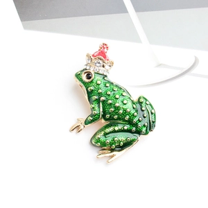 Detailed macro view of a green frog brooch with gold polka dots and a sparkling crown