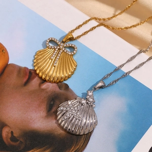 Detail of shell pendants with starfish and bow in gold and silver stainless steel