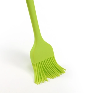 Single light green silicone oil brush for baking and BBQ on white background