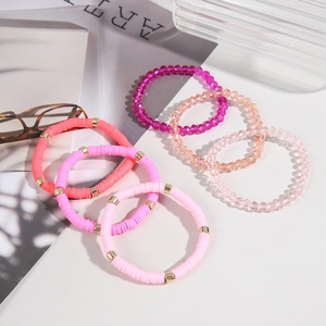 Detail of 6pcs bohemian pink heishi and crystal bead bracelets set on art magazine