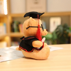 Detail of graduation teddy bear with black gown, mortarboard cap, and mini diploma