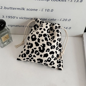 Close-up of leopard print canvas drawstring bag with beige cotton ropes in a lifestyle setting