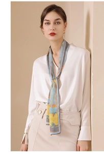 Artistic abstract print long narrow silk scarf tied as a necktie over a white shirt