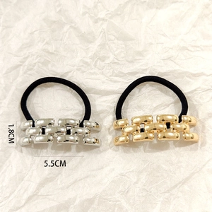Detail showing gold and silver chain link metal charms on black elastic hair ties