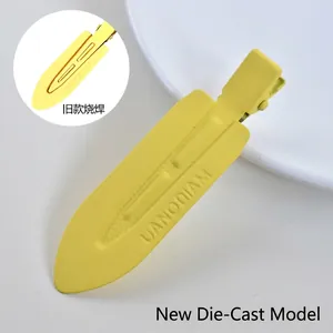 Detail of yellow matte metal duckbill hair clip with UANODIAM engraving and press opening