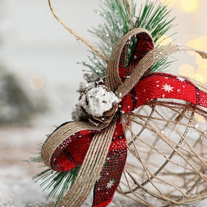 Rustic hollow Christmas ball ornament with tartan bow, pine cones and artificial snow