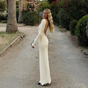 Detalle de vestido de punto blanco con espalda abierta y bordes ondulados en contraste negro